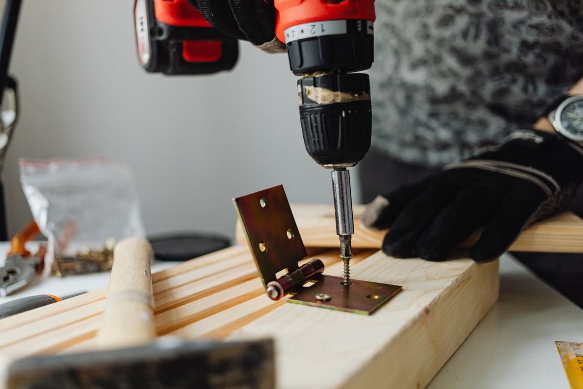 Close-up of metal hinge installation on wood for cabinet hardware