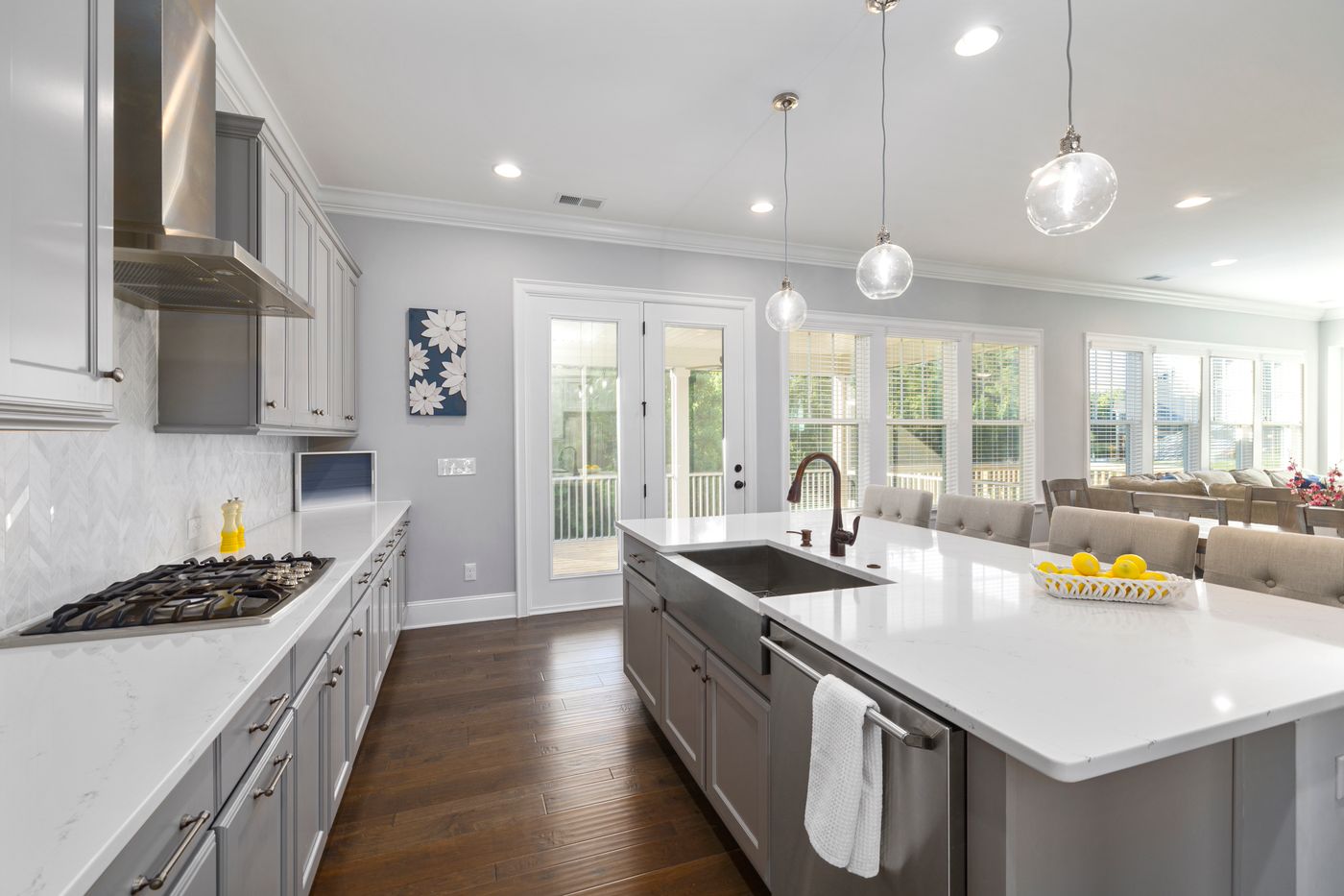 Finished bright white kitchen with custom cabinets, island, and marble-look countertops