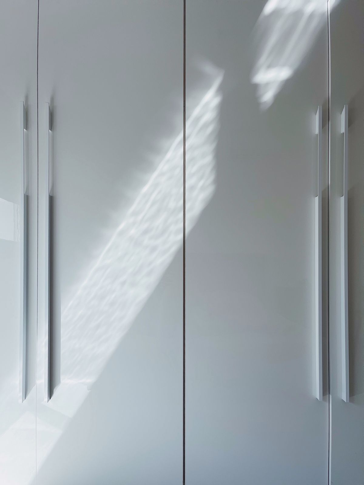Minimal white cabinet doors with slim modern pull handles