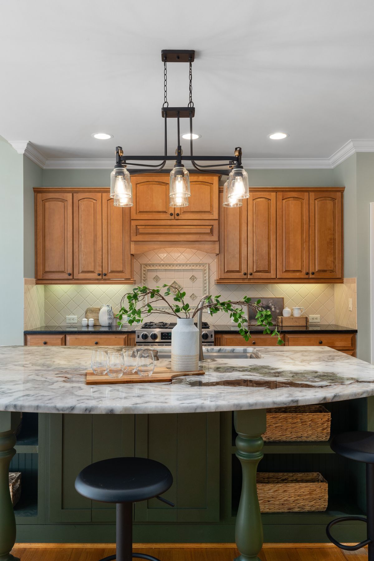 Kitchen island with polished marble countertop and warm wood cabinets