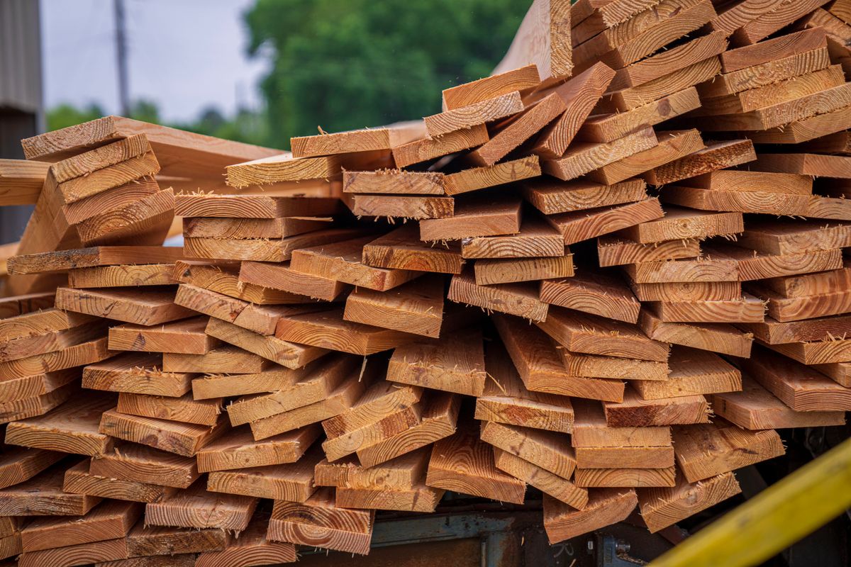 Stacked solid wood lumber showing natural grain for premium cabinetry