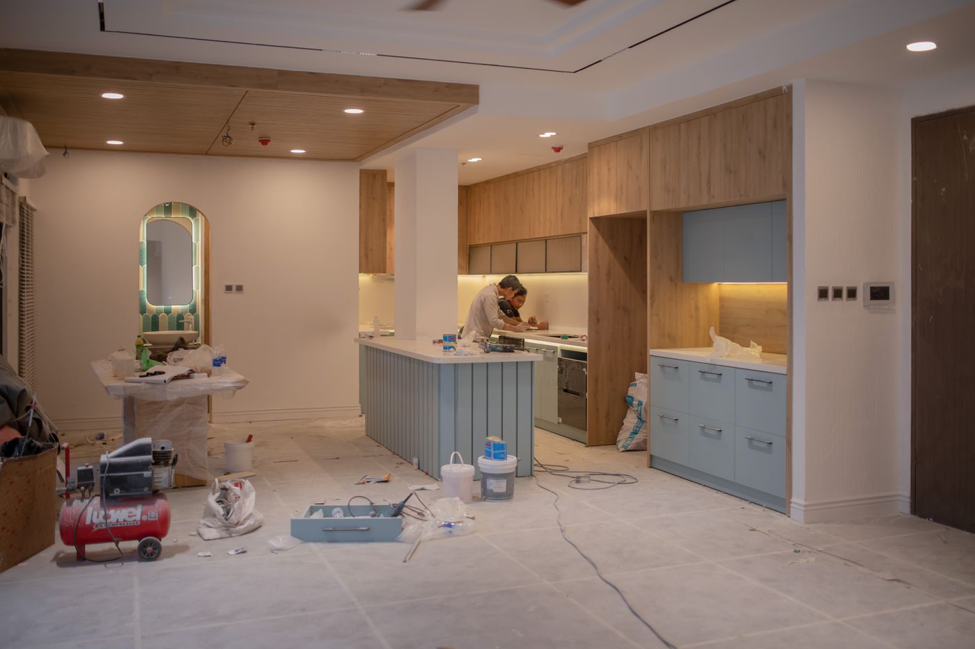 Kitchen under renovation with cabinetry, tools, and unfinished flooring before remodel completion