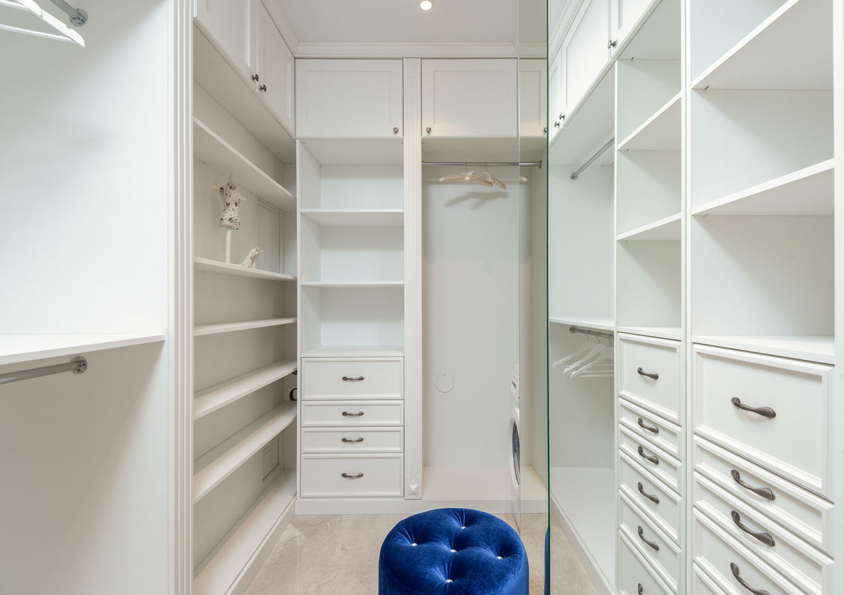 White walk-in closet with built-in shelves and hanging storage