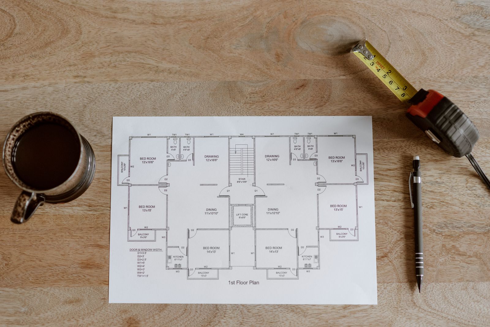 Floor plan and measuring tools reviewed before a custom cabinet quote